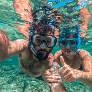 Photo of a couple snorkeling. Photo taken underwater.